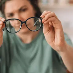 Kobieta z wadą wzroku 0.75 zastanawia się, czy nosić okulary.
