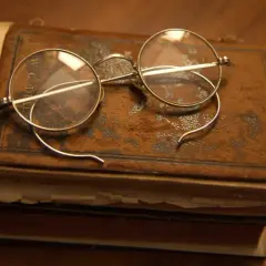 Stare okulary na zabytkowej księdze, jakbyśmy cofali się do czasów, kiedy wynaleziono okulary.