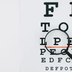 Tablica optometryczna z lupą, badanie wzroku ujawnia astygmatyzm nieregularny.