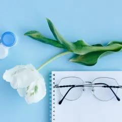 Pudełko na soczewki, biały kwiat i okulary na notatniku. Jak dobrać krzywiznę soczewki?