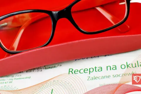 Okulary w etui, obok dokument z nagłówkiem "Recepta na okulary".