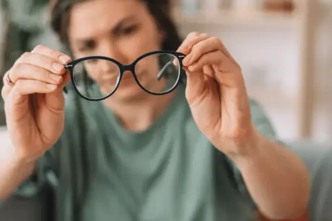 Kobieta z wadą wzroku 0.75 zastanawia się, czy nosić okulary.