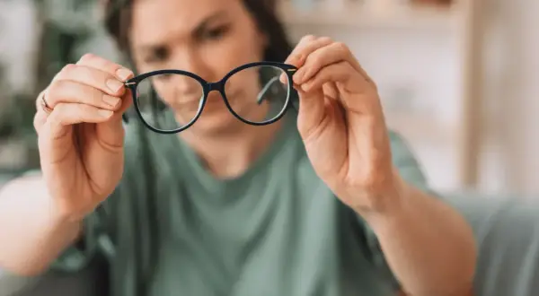 Kobieta z wadą wzroku 0.75 zastanawia się, czy nosić okulary.