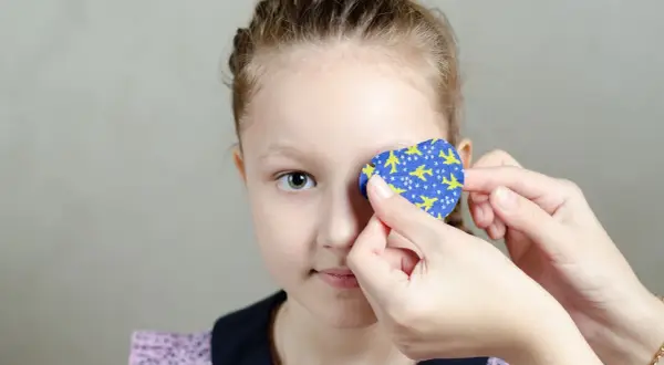 Dziecko z plastrem na oku z motywem samolotów.