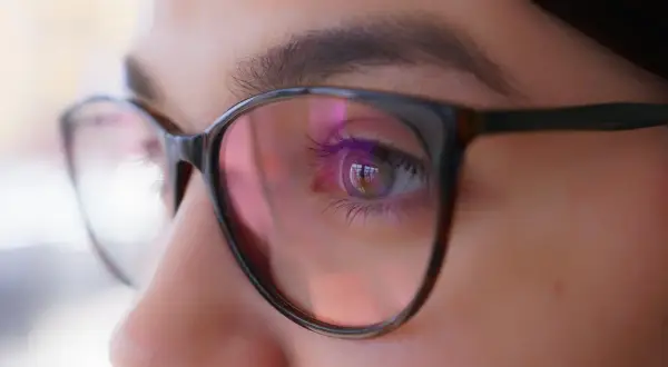 Oko w okularach, odbicie światła sugeruje, że optometrysta źle dobrane szkła.