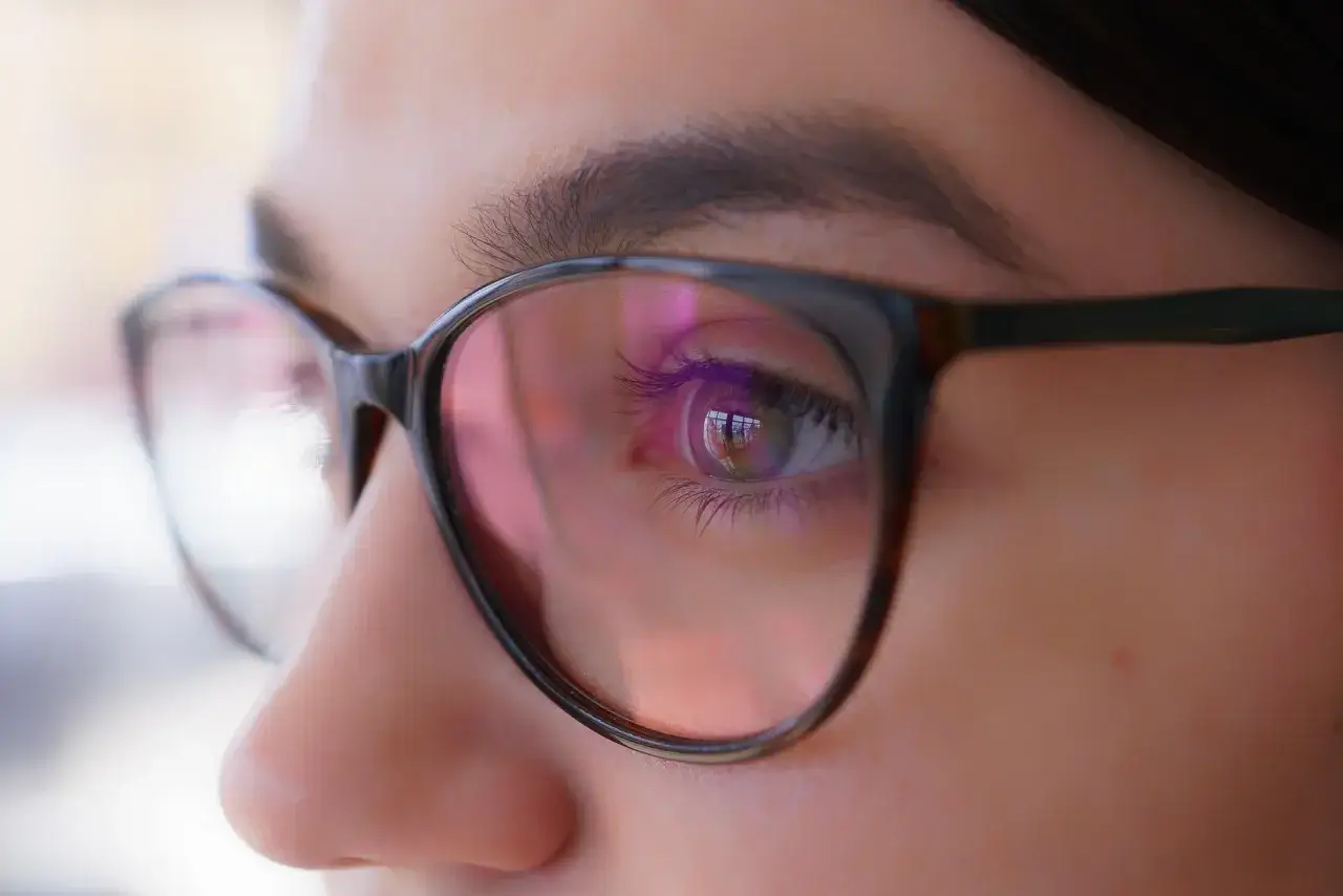 Oko w okularach, odbicie światła sugeruje, że optometrysta źle dobrane szkła.