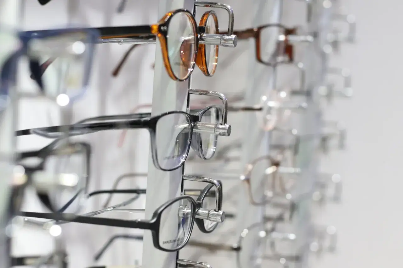 Rzędy okularów na wystawie. Różne modele, kolory i kształty. Zastanawiasz się nad plusy i minusy okulary?