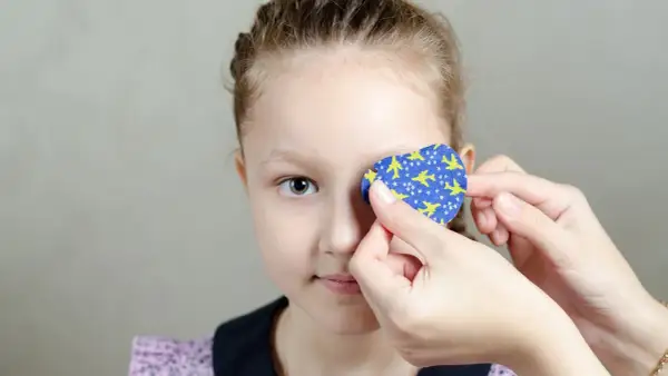 Dziecko z plastrem na oku z motywem samolotów.