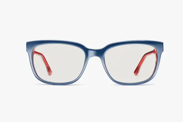 Eleganckie okulary korekcyjne w granatowej oprawce z czerwonymi zausznikami. Niebieskie szkła w okularach korekcyjnych zapewniają komfort widzenia.